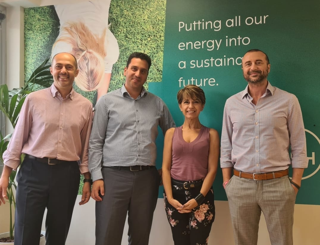 Group photo in front of sign „Putting all our energy into a sustainable future”